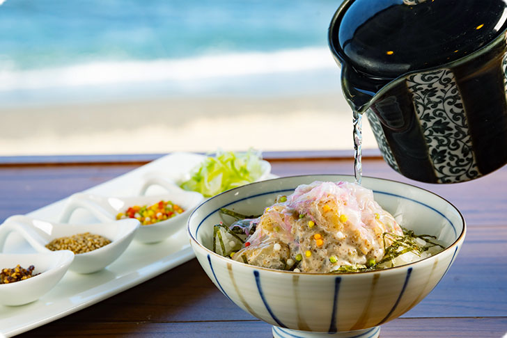 特性ゴマダレに漬け込んだ刺し身をご飯に載せ、お好みの薬味とあつあつの特性出汁をかけてつくるだし茶漬け。ゴマや刻み海苔などのトッピングをご用意しております。